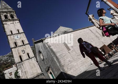 A street scene in the town of Perast depicting the St. Nicholas church bell tower. Stock Photo