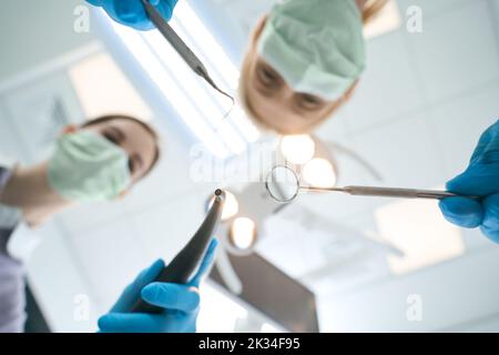 Assistant and dentist cleaning teeth from plaque Stock Photo