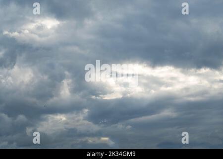 Cumulus nimbus clouds with the sun peeking through Stock Photo