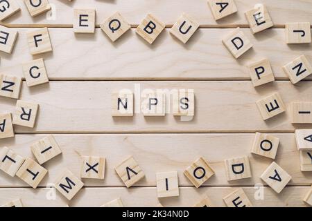 Inscription NPS and letter cubes on light wooden background Stock Photo