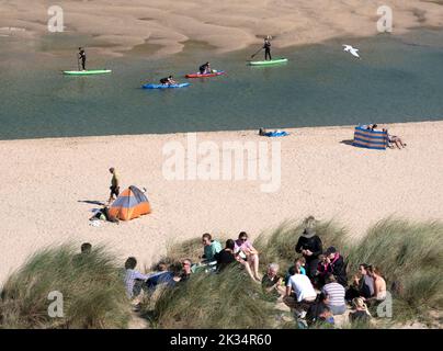 Holiday makes on sea and sand enjoying the sunshine on Crantock beach in Cornwall, England. Stock Photo