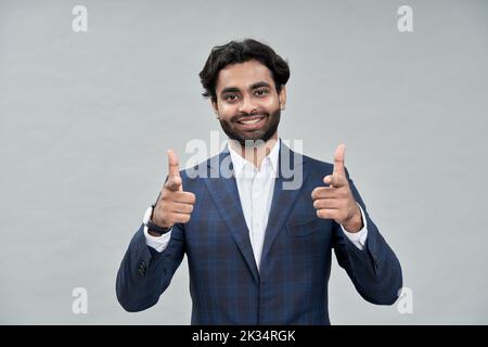 Smiling indian arab business man pointing at you isolated on beige. Stock Photo
