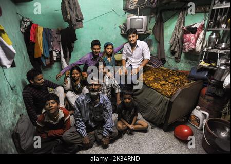 07.12.2011, Mumbai, Maharashtra, India, Asia - Family members pose for a photo in their narrow and modest dwelling in the Dharavi slum area of Mumbai. Stock Photo