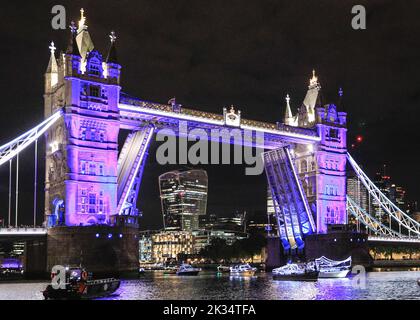 London, UK, 24th Sep 2022. The flotilla reaches Tower Bridge, illuminated in purple as a tribute to the Queen. Reflections, a night-time flotilla, on the River Thames in London, marks the passing of Her Majesty the Queen and the accession of King Charles III. Part of Totally Thames, the illuminated flotilla travels from Chelsea Bridge to Tower Bridge, with the Queen's row barge Gloriana, as its centrepiece. Credit: Imageplotter/Alamy Live News Stock Photo