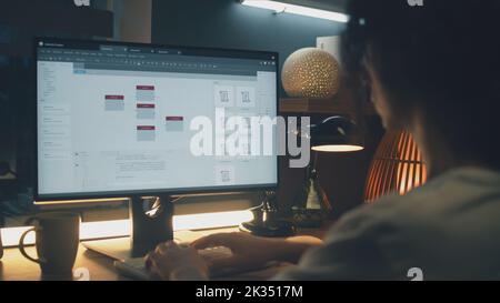 Male web designer using personal computer for creating website in professional constructor while working on project remotely at home. Freelance Stock Photo