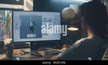 Male 3D designer sitting at the table at home and making animation for ...