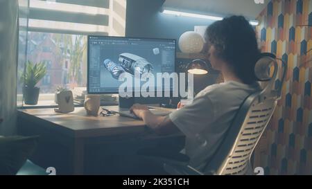Male young engineer using pc with professional program and creating 3D prototype of airplane turbine while working remotely at home office Stock Photo