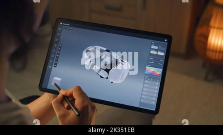Young male 3D designer drawing and creating 3D prototype of VR headset in professional design application on tablet using digital pencil Stock Photo