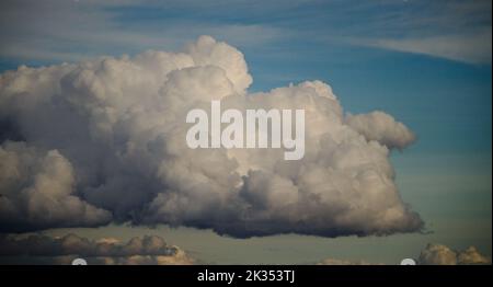 A large cumulus clouds set against a pale blue sky. Stock Photo