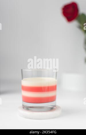 Vanilla and strawberry panna cotta in a glass, cooked cream dessert in a glass cup, white and pink layered panna cotta Stock Photo