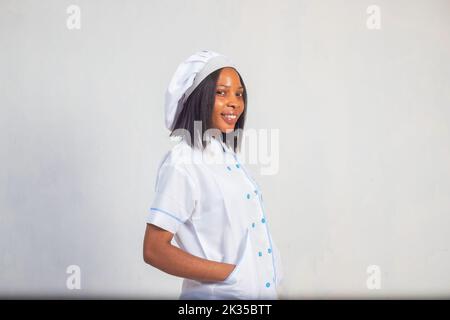 An African-American female in a white uniform smiling against a white background Stock Photo