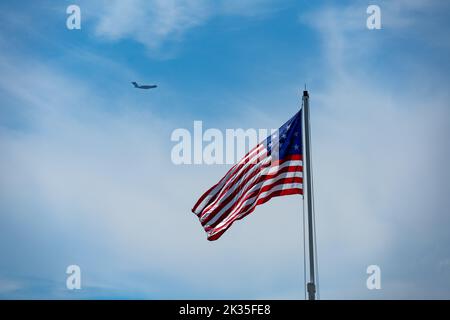 Star Spangled Banner flag flying over Fort Moultrie flag with a Charleston C-17 flying in the background Stock Photo