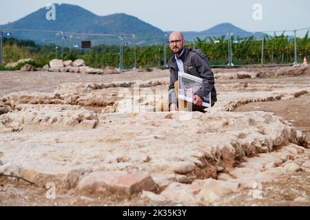 Landau, Germany. 13th Sep, 2022. David Hissnauer, archaeologist at the Speyer field office of the Rhineland-Palatinate Directorate General for Cultural Heritage, crouches next to the remains of a Roman military camp on the B10 highway. During work on the four-lane expansion of the B10 between Landau-Godramstein and the A65, remains from Roman times were found. (to dpa 'Highlight': Find of late antique military camp inspires researchers') Credit: Uwe Anspach/dpa/Alamy Live News Stock Photo