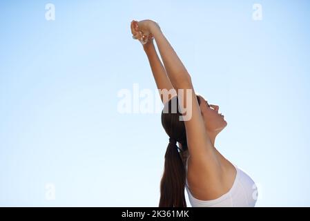Embracing the world before a workout. A pretty spo stretching her arms out before a workout. Stock Photo
