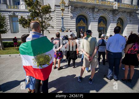 Protesters gather outside the city hall with the flag of Iran during the demonstration. After the death of the young Iranian girl Mahsa Amini, protests and demonstrations appeared in different cities of Iran. Outside Iran, protests and rallies to support people in Iran also happen across the world. In San Francisco, a few people protested outside the San Francisco City Hall. The protesters say they want to express their voice to the Iranians and let them know there are many people support them in the world. Also, there are some Iranians join the protest and speak on the protest. Stock Photo