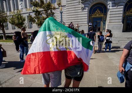 Protesters gather outside the city hall with the flag of Iran during the demonstration. After the death of the young Iranian girl Mahsa Amini, protests and demonstrations appeared in different cities of Iran. Outside Iran, protests and rallies to support people in Iran also happen across the world. In San Francisco, a few people protested outside the San Francisco City Hall. The protesters say they want to express their voice to the Iranians and let them know there are many people support them in the world. Also, there are some Iranians join the protest and speak on the protest. Stock Photo