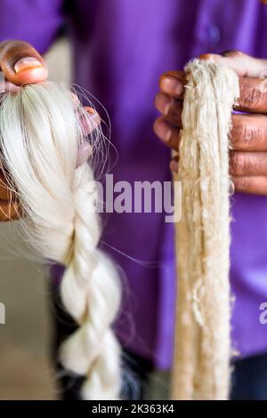 Man holds two Beautiful silk weave products to make slik clothing. Stock Photo