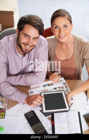 Now you can submit your designs online. young design professionals using a digital tablet while editing images. Stock Photo