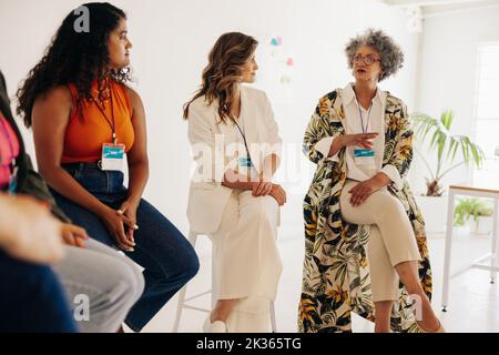 Group of diverse businesswomen having a discussion during a conference meeting. Multicultural businesswomen sharing ideas while working together in an Stock Photo