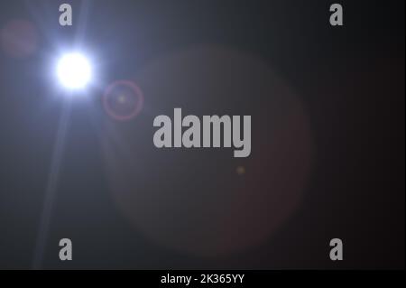 star flare in black background. Realistic lens flare in black background. Lens Flare. Blue Light over black background. add overlay or screen filter o Stock Photo