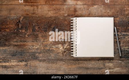 Vintage sketchbook with pen and pen on old rustic wooden table. Mockup blank notebook and pen on old rustic wooden table Stock Photo