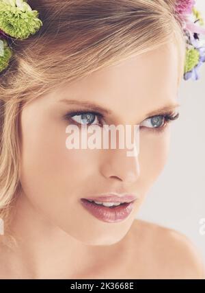 Her beauty is all natural. Studio shot of a beautiful young woman with flowers in her hair. Stock Photo