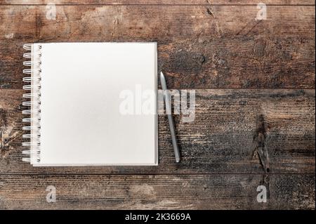 Blank notebook on vintage wooden table. mockup notebook on old rustic desk. Mockup blank notebook and pen on old rustic wooden table. top view. copy s Stock Photo