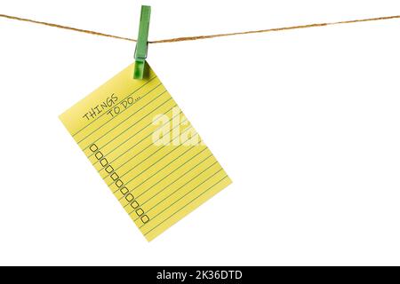 New Year New Goals. Yellow Sticky Note Paper on a clothesline isolated on white. To do list Stock Photo