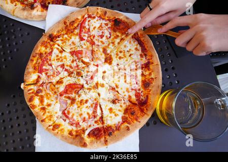 Traditional and authentic Italian pizza baked in wood fired oven. On table with ingredients. Stock Photo