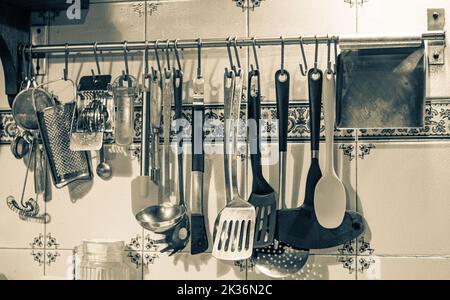 Black and white photo. Kitchen utensils hanging on the wall. Stock Photo