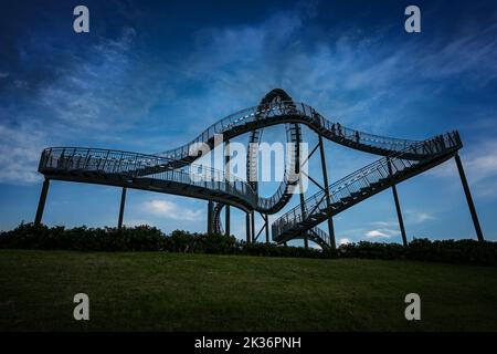 Tiger and Turtle, a walkable roller coaster sculpture on Magic Mountain against a dark cloudy sky at the blue hour, art installation and landmark in A Stock Photo