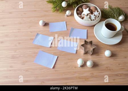 Blank post it notes on a wooden desk with coffee, cookies and fir branches, for example for new year's resolutions or goals, copy space, selected focu Stock Photo