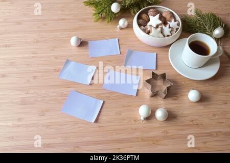 Blank sticky notes on a wooden desk with coffee, cookies and fir branches, for example for new year's resolutions or goals, copy space, selected focu Stock Photo