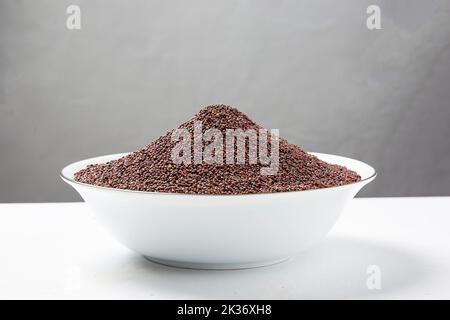 mustard seeds in the wooden scoop, isolated on white.Rai or brown mustard seedsmustard seeds in the wooden scoop, isolated on white.Rai or brown musta Stock Photo