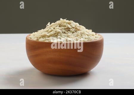 Raw Flattened Rice or Thick or thin Rice Flakes for Namkeen Chivda snacks or Aloo Poha for Indian Breakfast, served in a bowl. Stock Photo