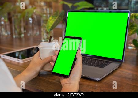 Close up of woman using smartphone and laptop in cafe, texting,video calls,shopping. Stock Photo