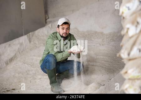 Man farmer checking quality of maize flour Stock Photo