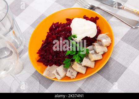 Sliced herring with grated beetroot served on table Stock Photo