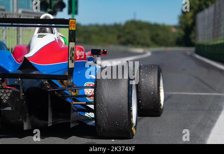 Rear view of racing formula car with asphalt racetrack defocused in background from pit lane. Vallelunga, Italy, september 17-18 2022, Racing weekend Stock Photo