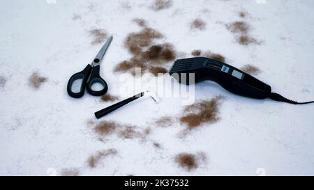close up of Barber tools and a lot of cut hair from the body, on white background. tools for depilation, hair removal, Men's haircut. clipper, electric razor, trimer, scissors. High quality photo Stock Photo