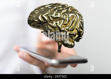 The hand holding the smartphone with the golden 3d brain illustration above the screen Stock Photo
