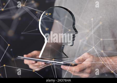 The male hands holding the tablet with the human head above the screen. Artificial intelligence concept Stock Photo