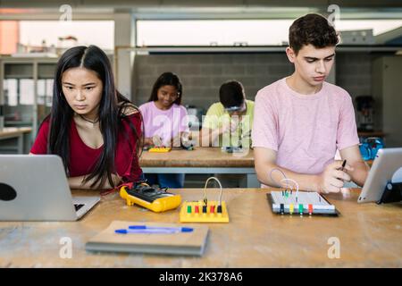 Multiracial group of high school students programming electronic circuits Stock Photo