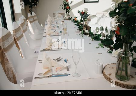 Rustic Wedding Reception Top Table seating with glasses, cutlery and dishes Stock Photo