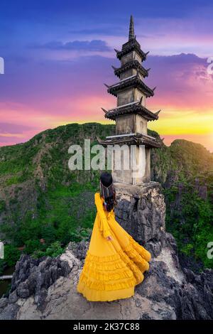 Woman tourist standing at pagoda near Hang Mua viewpoint. Popular tourist attraction at Tam Coc, Ninh Binh. Vietnam. Stock Photo