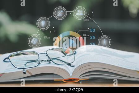 A simple composition of many books, stack or pile of books on wooden table, one of them open and glasses with icons save CO2 and energy sources for re Stock Photo