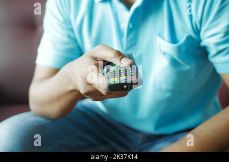 close up of man hand holding tv remote. Stock Photo