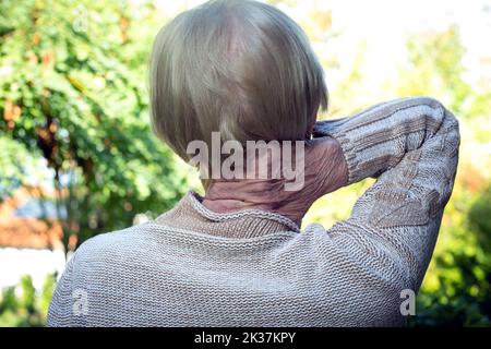 close-up of old woman rubbing her neck Stock Photo