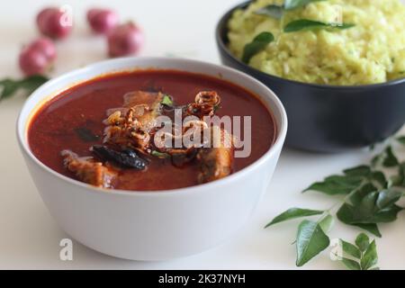 Indian butter fish curry prepared in kerala style served with Mashed tapioca. Shot on white background Stock Photo
