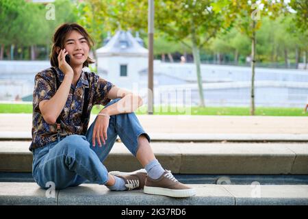 Asian guy talking on the smartphone at street. Stock Photo